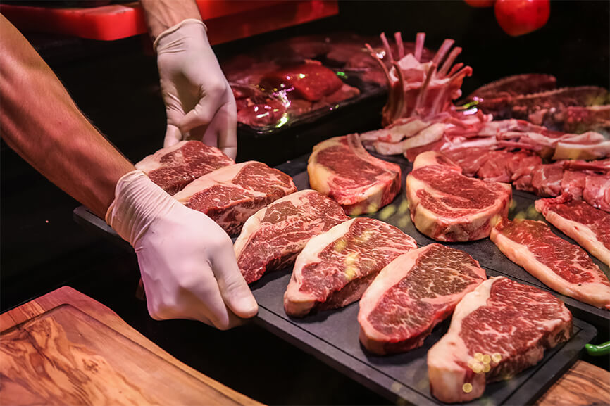 An image of steaks on wooden board