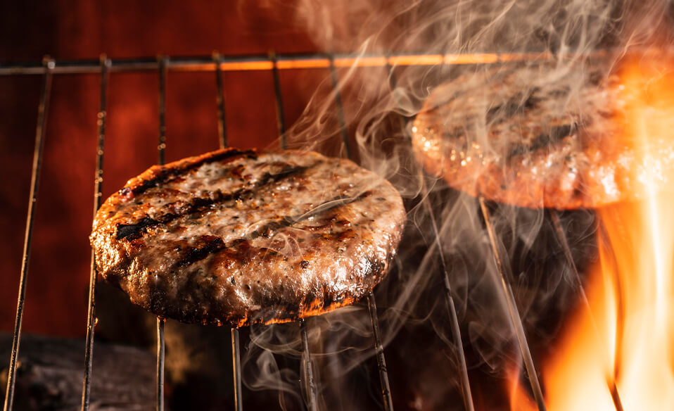 An image of two burgers on a grill